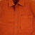 Detail shot of Topo Designs Men's Dirt Shirt in Brick orange showing buttons and chest pocket.