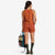 Back of Topo Designs Women's 30+ UPF moisture wicking River Tank top in clay orange terrazzo print on model.